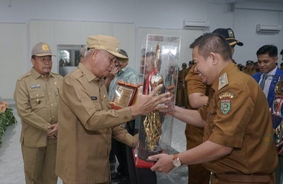 Bupati Asahan Surya saat menyerahkan piala kepada Desa Terbaik 2024.