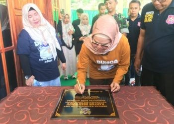 Bupati Merlan S. Uloli saat menandatangani prasasti peresmian Kantor Desa Boidu, Kecamatan Bulango Utara, Senin (1/7/2024). (F. Indra)