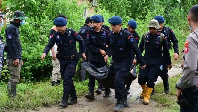 Anggota Polda Gorontalo saat mengevakuasi jenazah korban longsor di Desa Tulabolo, Kecamatan Suwawa Timur, Kabupaten Bone Bolango, Selasa (8/7/2024). (Foto : Haris)