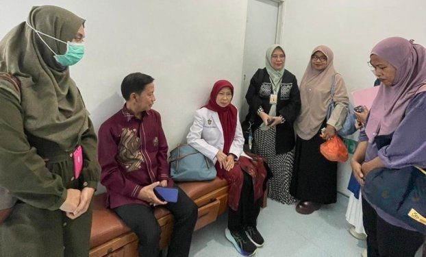Kadis Kesehatan Provinsi Gorontalo Anang S. Otoluwa bersama orang tua penerima bantuan dari Presiden RI saat menunggu operasi yang sedang berlangsung.