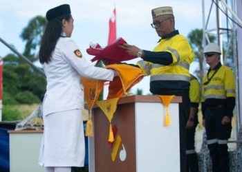Direktur Utama PT Gorontalo Sejahtera Mining (GSM) dan PT Puncak Emas Tani Sejahtera (PETS), Boyke P Abidin, selau inspektur upacara menyerahkan bendera merah putih kepada Paskibra pada peringatan HUT RI di Pani Gold Project Pohuwato