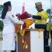 Direktur Utama PT Gorontalo Sejahtera Mining (GSM) dan PT Puncak Emas Tani Sejahtera (PETS), Boyke P Abidin, selau inspektur upacara menyerahkan bendera merah putih kepada Paskibra pada peringatan HUT RI di Pani Gold Project Pohuwato