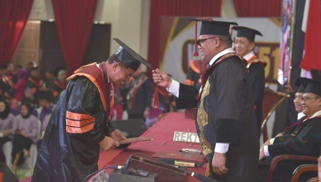 Rektor UNG, Eduart Wolok mengukuhkan salah satu wisudawan UNG.