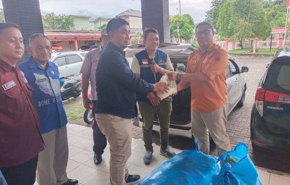Pj Sekda Bone Bolango, Aznan Nadjamudin saat menyerahkan bantuan paket sembako kepada warga Kecamatan Bone yang terdampak banjir