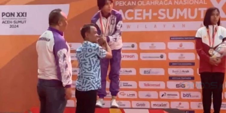 Atlet muaythai Gorontalo, Fatimah Catherina Husain, menerima pengalungan medali emas pada PON XXI di Gedung Balle Meusarayya, Aceh, Selasa (10/9/2024). (Foto : Istimewa)