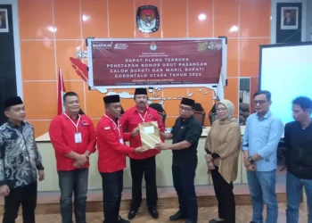 Ketua KPU Gorut Sofyan Jakfar menyerahkan berita acara perubahan nomor urut paslon dalam Pilkada Serentak 2024. (Saprin/hulondalo.id)
