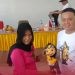 Anggota KPU Gorut Noval Katili menyerahkan boneka maskot Pilkada kepada warga Anggrek setelah kegiatan sosialisasi, Senin (28/10/2024).