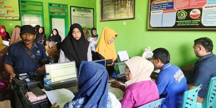 Petugas Dinas Kependudukan dan Pencatatan Sipil Kabupaten Bone Bolango saat memberikan layanan dokumen kependudukan kepada warga. (Foto Istimewa)