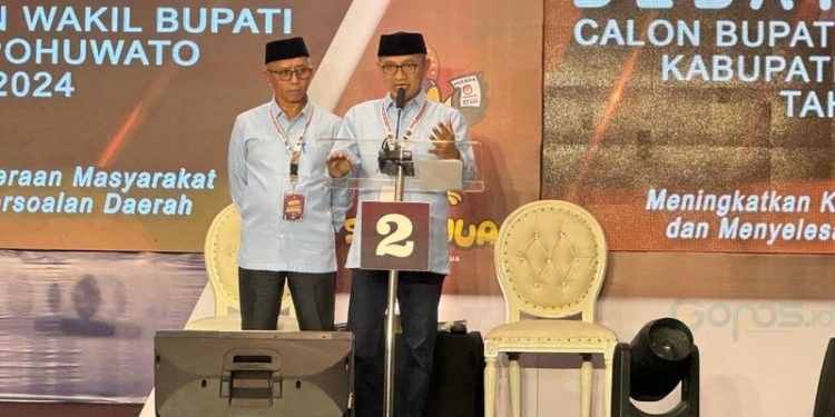 Pasangan calon Bupati dan Wakil Bupati Pohuwato Saipul Mbuinga dan Iwan Adam saat debat perdana, Minggu (27/10/2024).