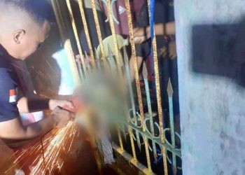 Proses evakuasi kaki korban yang terjebak di pintu pagar besi. (Nandar/Gopos)