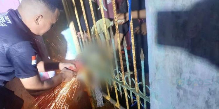 Proses evakuasi kaki korban yang terjebak di pintu pagar besi. (Nandar/Gopos)