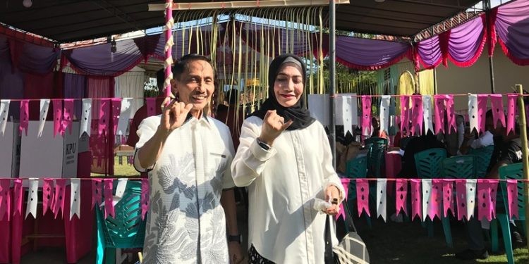 Nelson Pomalingo bersama istri usai menyalurkan suaranya di TPS 02 Tinelo.(Foto Arif Gopos)