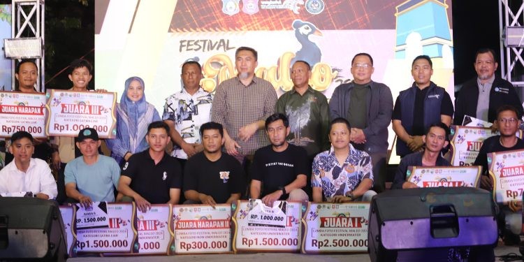 Pjs Bupati Bone Bolango, Budiyanto Sidiki didampingi Kepala Seksi Pengelolaan Taman Nasional (SPTN) Wilayah I Balai Taman Nasional Bogani Nani Wartabone, Bagus Tri Nugroho saat foto bersama dengan pemenang lomba photography pada rangkaian penutupan Festival Maleo 2024 di Kawasan Objek Wisata Danau Perintis, Minggu (18/11/2024) malam tadi. (Foto Indra/Gopos)