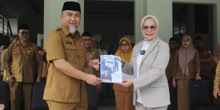 Pjs Bupati Bone Bolango 2024, Budiyanto Sidiki saat menyerahkan nota kinerja kepada Bupati Bone Bolango, Merlan S. Uloli, Senin (25/11/2024). (Foto Yudi/Prokopim)