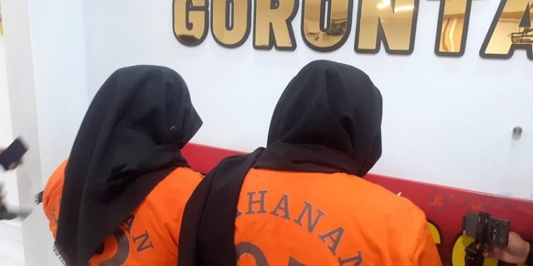Dua IRT berinisial MP dan FS asal Kecamatan Dungingi saat konferensi pers di Polresta Gorontalo Kota terkait kasus skincare ilegal, Rabu (13/11/2024).(Foto Nandar Gopos)