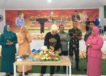 Bupati Merlan S. Uloli saat melakukan pemotongan tumpeng buah pada perayaan Hari Ulang Tahun (HUT) ke-25 Dharma Wanita Persatuan (DWP) yang dilaksanakan di Bandayo Li Mbui, Kecamatan Kabila, Jumat (13/12/2024). (Foto Indra/Gopos)