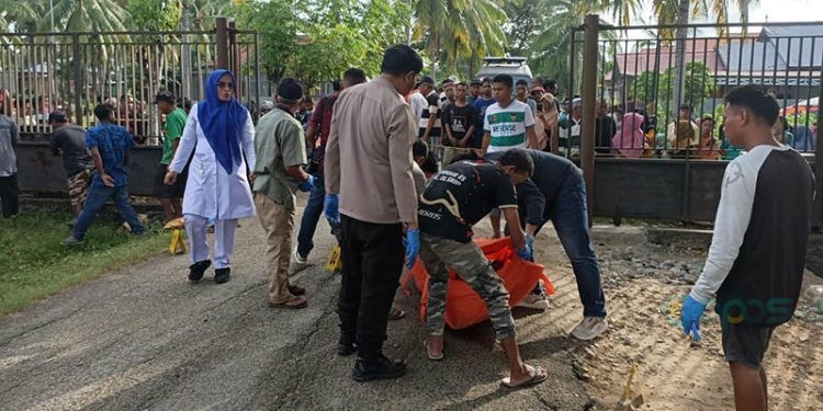 Petugas Kepolisian mengevakuasi jasad seorang pria yang ditemukan tak bernyawa di depan SDIT Permata Umat Isimu, Kecamatan Tibawa, Kabupaten Gorontalo, Kamis (12/12/2024)