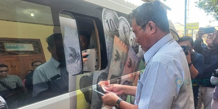 Salah seorang warga Kota Gorontalo, Fredrik PUtow, menukarkan uang pecahan kecil pada layanan kas keliling KPw BI Gorontalo dalam kegiatan SERUNAI 2024, Ahad (15/12/2024).(Hasan/gopos)