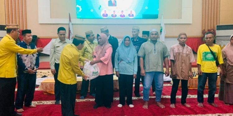 Ketua Baznas Provinsi Gorontalo Hamka Arbie saat membagi-bagikan sembako kepada perwakilan petugas kebersihan dalam kegiatan doa bersama HUT ke-24 Baznas, Kamis (23/1/2025).(Foto Rama Gopos)