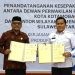 Ketua DPRD Kota Kotamobagu Adrianus Mokoginta (kiri) bersama Kakanwil Kemenkum Sulut Kurniaman Telaumbanua usai penandatanganan kesepakatan bersama terkait kerjasama pembentukan produk hukum berkualitas di daerah.(Foto Kanwil Kemenkum Sulut)
