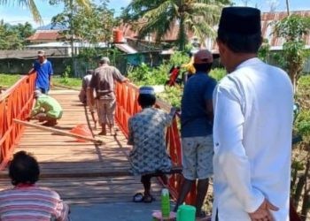 Warga Desa Molowahu, bergotong royong memperbaiki jembatan yang rusak. (Foto: Isitimewa)