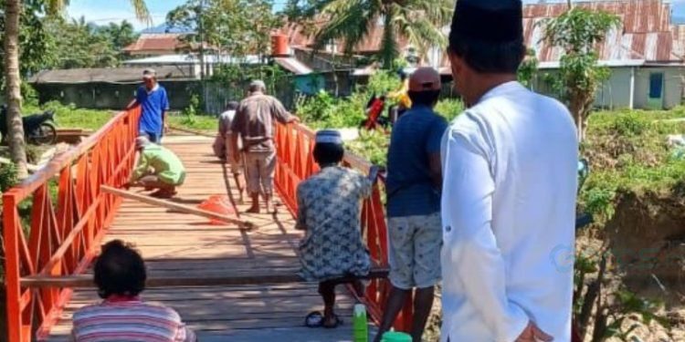 Warga Desa Molowahu, bergotong royong memperbaiki jembatan yang rusak. (Foto: Isitimewa)