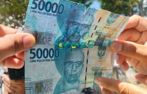 Uang asli (bawah) uang palsu (atas). (Putra/Gopos)