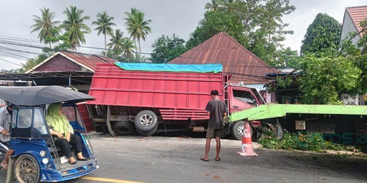 Kondisi truk yang mengangkut air dalam kemasan terperosok usai menabrak tembok pagar rumah warga di Jl. A. Hippy, Kelurahan Hunggaluwa, Kecamatan Limboto, Kabupaten Gorontalo, Jumat (14/2/2025)