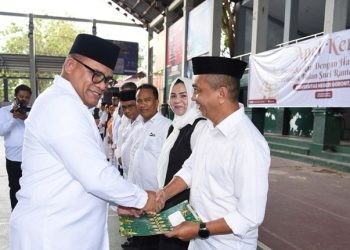 Rektor UNG Eduart Wolok ketika memberikan SK kepada 10 guru besar, bertempat di lapangan Indor UNG, Selasa (19/2/2025).(Foto/UNG)