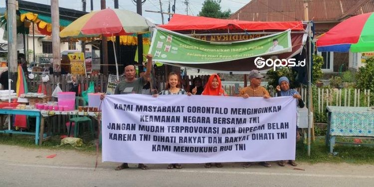 Sejumlah Masyarakat Gorontalo turun ke jalan untuk berbagi takjil sekaligus menyuarakan dukungan terhadap Undang-Undang Tentara Nasional Indonesia (UU TNI), Sabtu (29-3-2025).