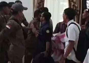 Pengunjuk rasa dan anggota saptol PP saling berhadapan saat aksi unjuk rasa di kantor Bupati Bone Bolango, Senin (17/3/2025)