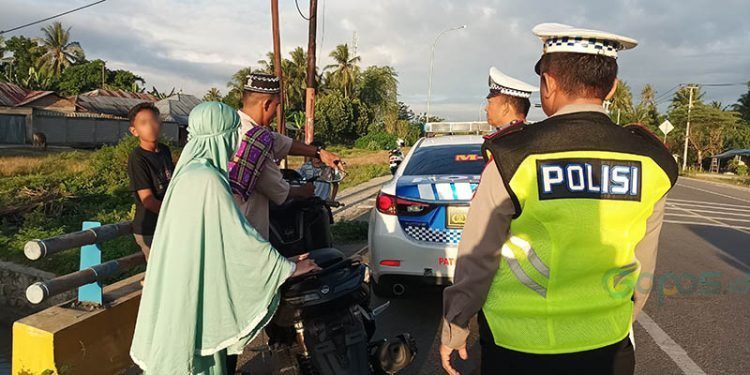 Salah seorang pengendara memasang perlengkapan sepeda motor berupa kaca spion dan plat TNK saat razia tim gabungan Polda Gorontalo dan Polres Gorontalo di jalan GORR, Sabtu (1/3/2025)