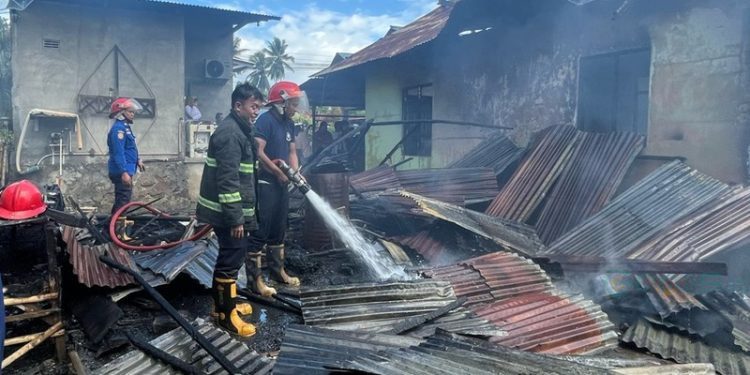 Petugas Damkar Gorontalo saat melakukan pendinginan rumah yang terbakar di Desa Pilohayanga, Kabupaten Gorontalo.(Foto Damkar)