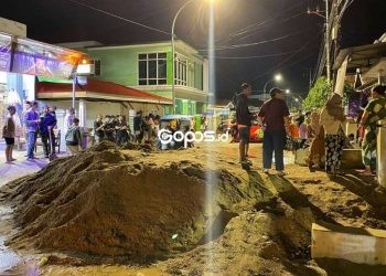 Warga Kelurahan Tenda membawa material pasir bekas longsor ke badan jalan Yos Sudarso sebagai bentuk protes kepada pemerintah yang belum memberi solusi terkait masalah longsor tersebut, Kamis (6/3/2025).(Foto Arif gopos)