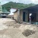 Kondisi rumah dari Mince Napu pasca diterjang banjir, Rabu (5/3/2025). Telihat sungai mendangkal akibat pasir yang dibawa air dari area perbukitan.(Foto Rama Gopos)