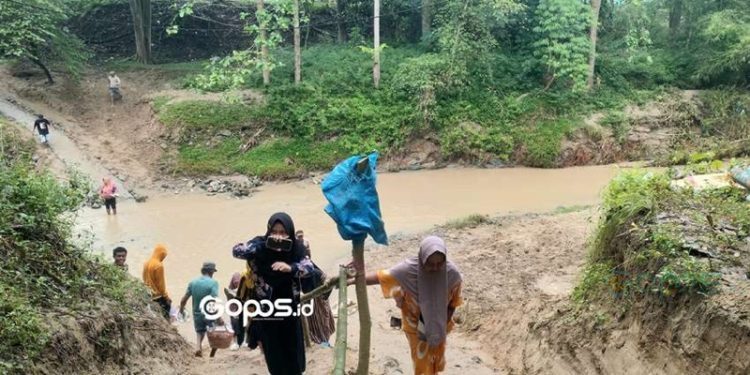 Sejumlah warga Desa Pulubala terpaksa menempuh jalur alternatif usai jembatan Pulubala yang menjadi penghubung ambruk.(Foto Putra Gopos)