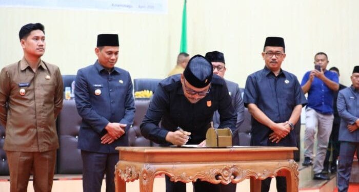 Ketua DPRD Kotamobagu Adrianus Mokoginta saat menandatangani nota kesepakatan rancangan awal RPJMD 2025-2029.