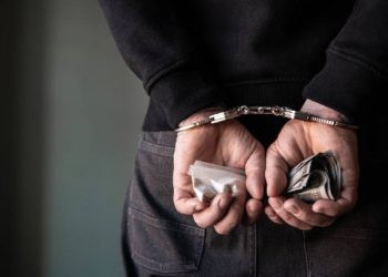 A criminal with handcuffs behind his back.