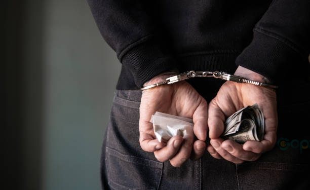 A criminal with handcuffs behind his back.