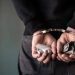 A criminal with handcuffs behind his back.