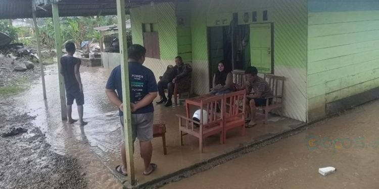 Salah satu rumah warga yang mulai digenangi air pasca meluapnya sungai di sepanjang Dusun Pohilatu.