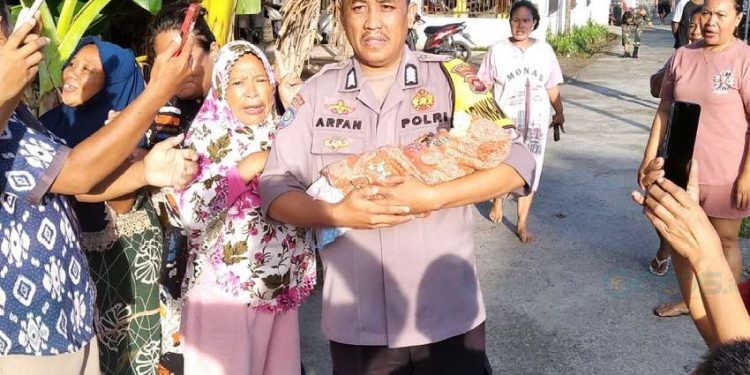 Pihak kepolisian saat membawa bayi berjenis kelamin laki-laki ke puskemas Suwawa.