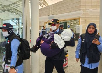 Petugas haji menggendong calon haji Indonesia setibanya di Bandara Amir Muhammad bin Abdul Aziz Madinah. (Foto ANTARA/HO-MCH 2025)