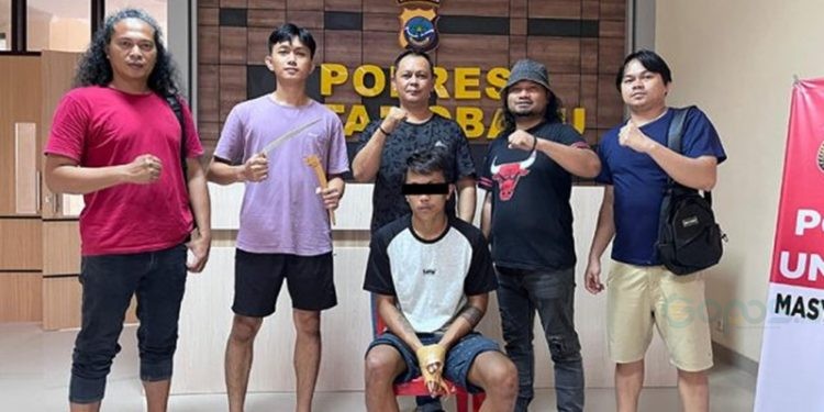 SP (25) tersangka kasus penganiayaan dengan senjata tajam saat diamankan Tim Resmob Polres Kotamobagu, Senin (19/5/2025).(Foto Polres KK)