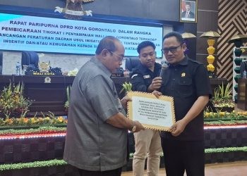 Ketua DPRD Kota Gorontalo Irwan Hunawa menerima draf Ranperda tentang Pemberian Insentif kepada Masyarakat dan Investor usul inisiatif Pemkot Gorontalo yang diserahkan Walikota Gorontalo Adhan Dambea, Senin (19/5/2025).(Foto Arni gopos)