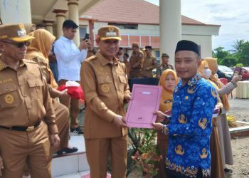 Bupati Pohuwato, Saipul Mbuinga, menyerahkan SK PPPK dan CPNS, berlangsung di halaman kontor bersama Bupati Pohuwato, Senin (02/06/2025) (Iwan Prokopim Pohuwato)