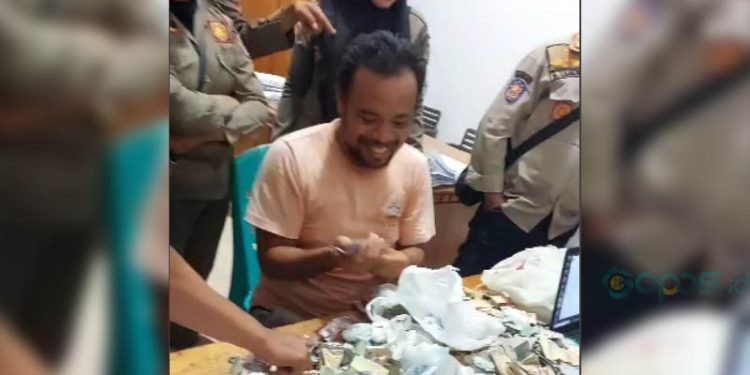 Lutfi, si Pengemis Kaya,menghitung uang yang dikumpulkan dari mengemis saat diamankan Satpol PP Kota Gorontalo, Kamis (3/7/2025)