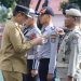 Gubernur Gorontalo Gusnar Ismail saat menyematkan pin dan pita kepada petugas gabungan dalam Apel Gelar Pasukan Operasi Patuh Otanaha 2025, Senin (14/7/2025).(F. Putra Gopos)