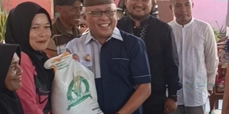 Bupati Gorontalo, Sofyan Puhi saat  membagikan beras CPP.