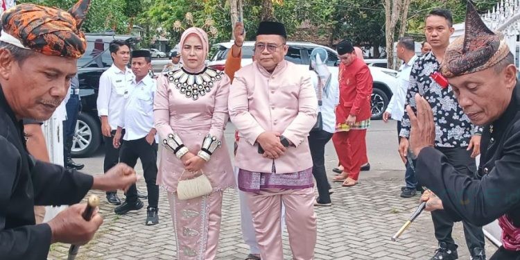 Sekretaris Daerah Kabupaten Gorontalo, Sugondo Makmur bersama istri, Seliyanti Makmur Ntoma saat menjalani prosesi adat mopotilolo.